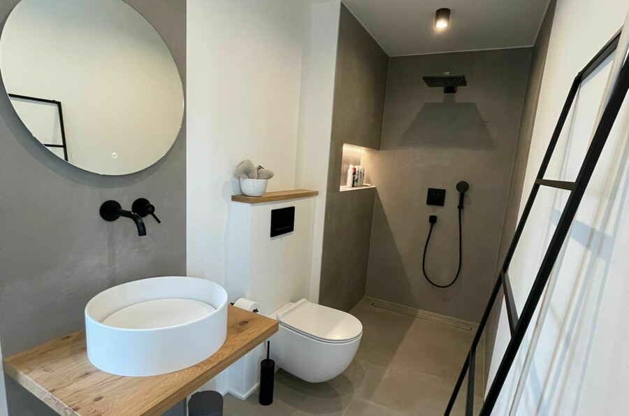Gäste Badezimmer mit rundem Spiegel und Aufsatzbecken