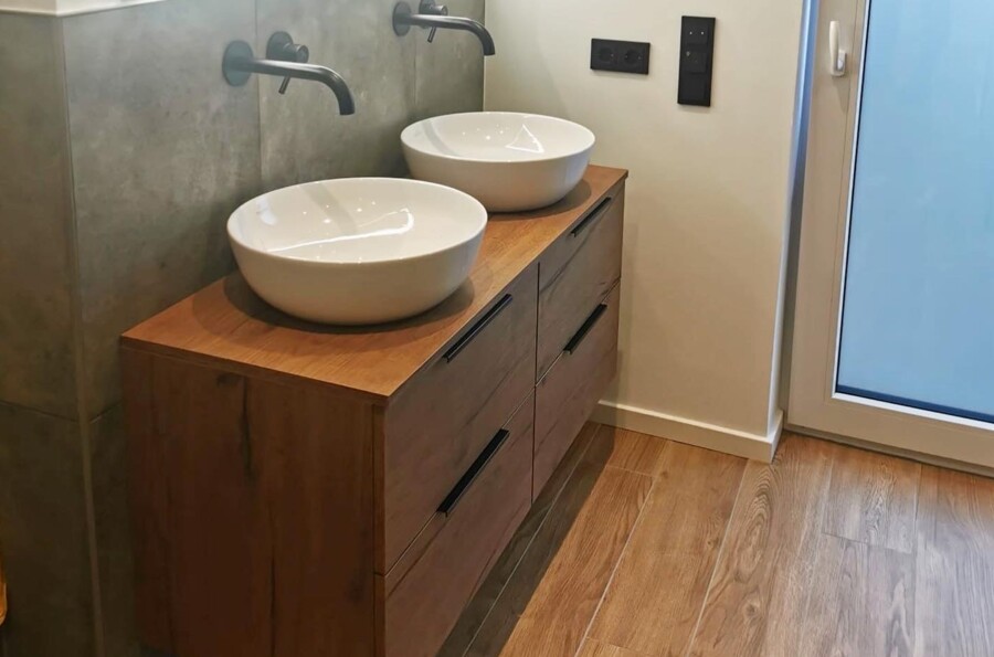 Badezimmer mit Holzoptik Fliesen im Bodenbereich und Waschtisch in Holzoptik